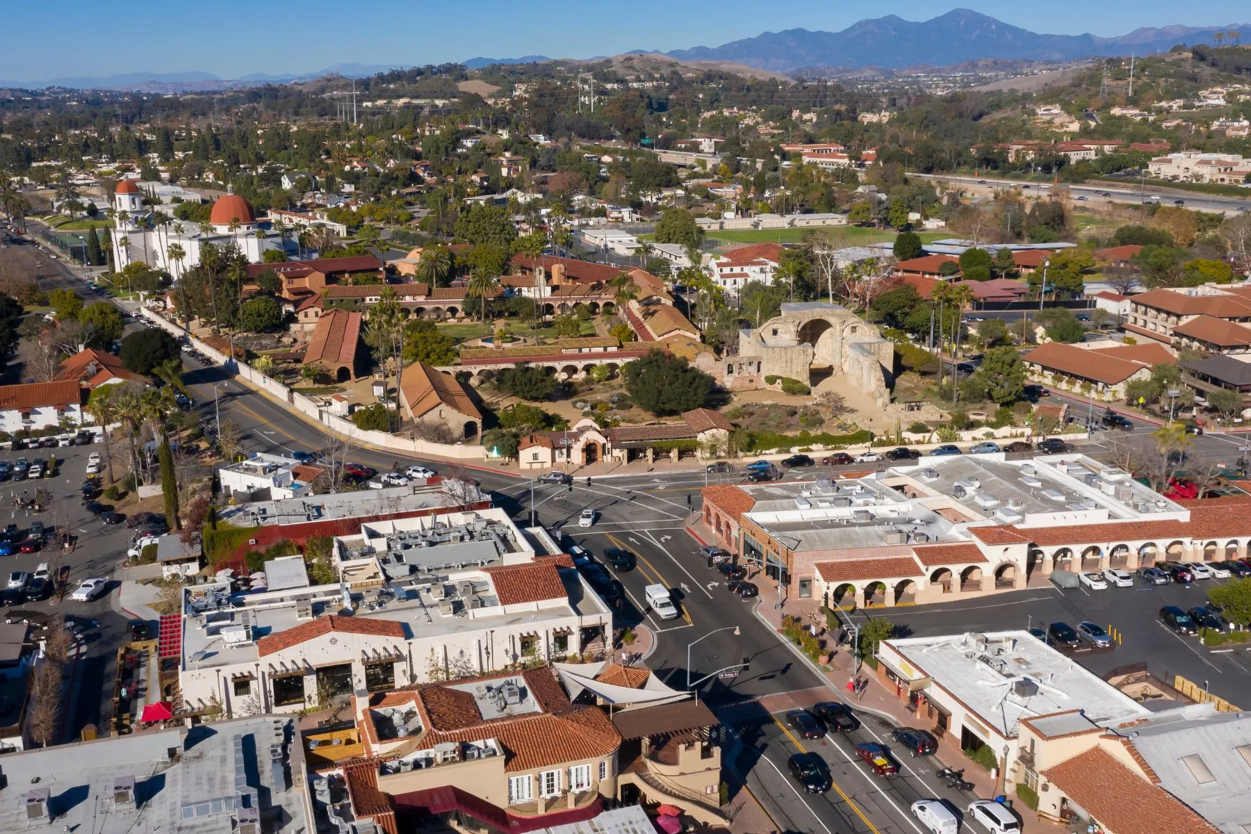 Area with buildings, roads, greenery, and hills