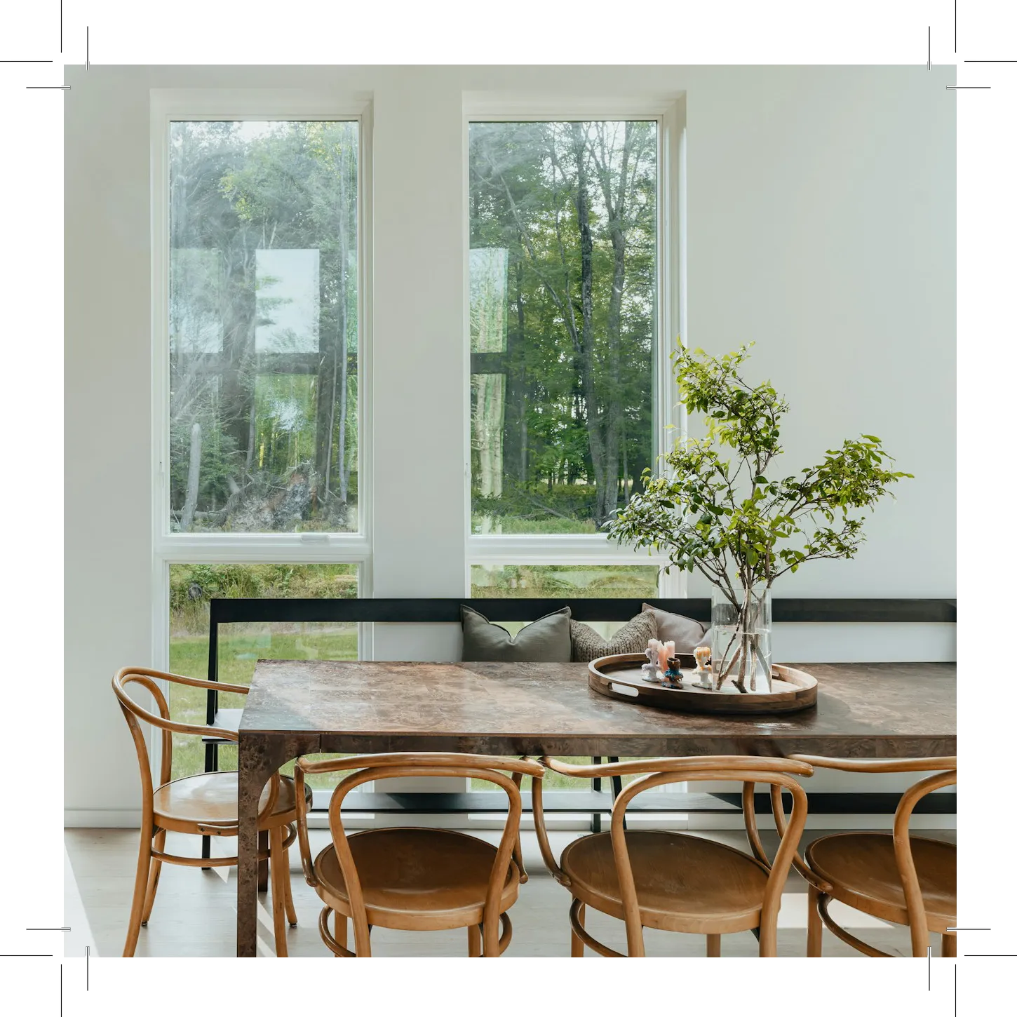 Dining area with wooden table, chairs, and big windows