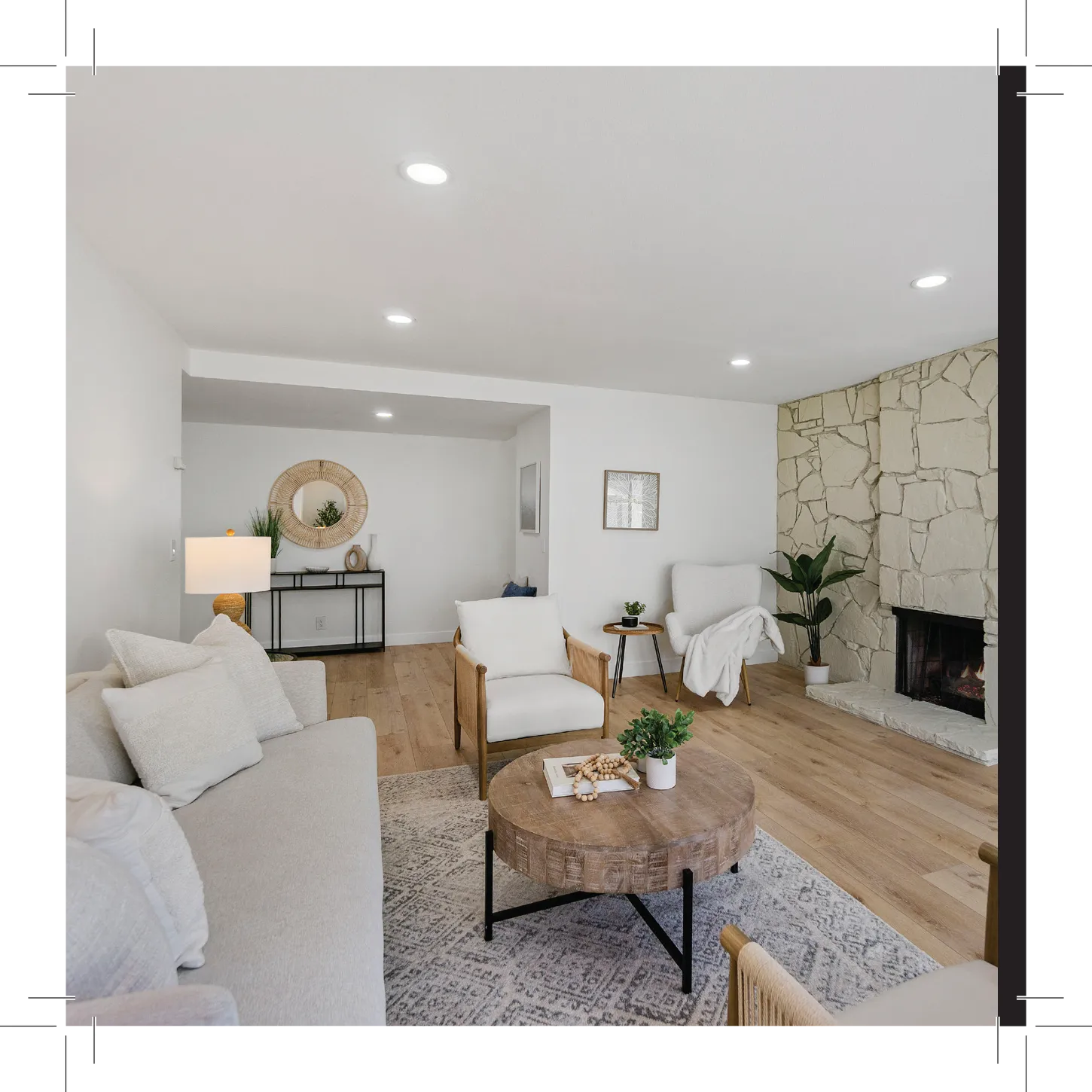 Living room with sofa, chair, table, fireplace, and plants