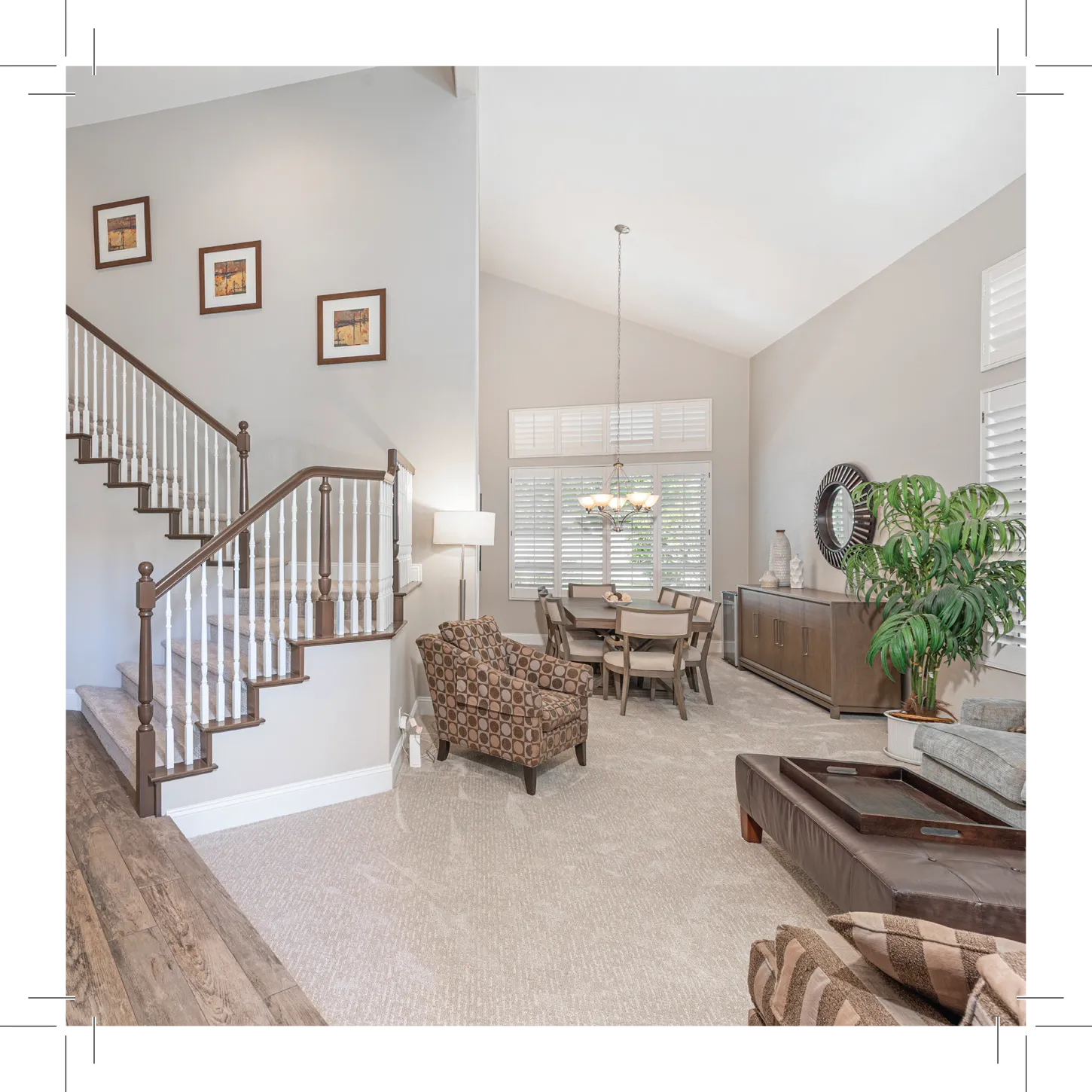 Living area with stairs, sofa, table, and big windows