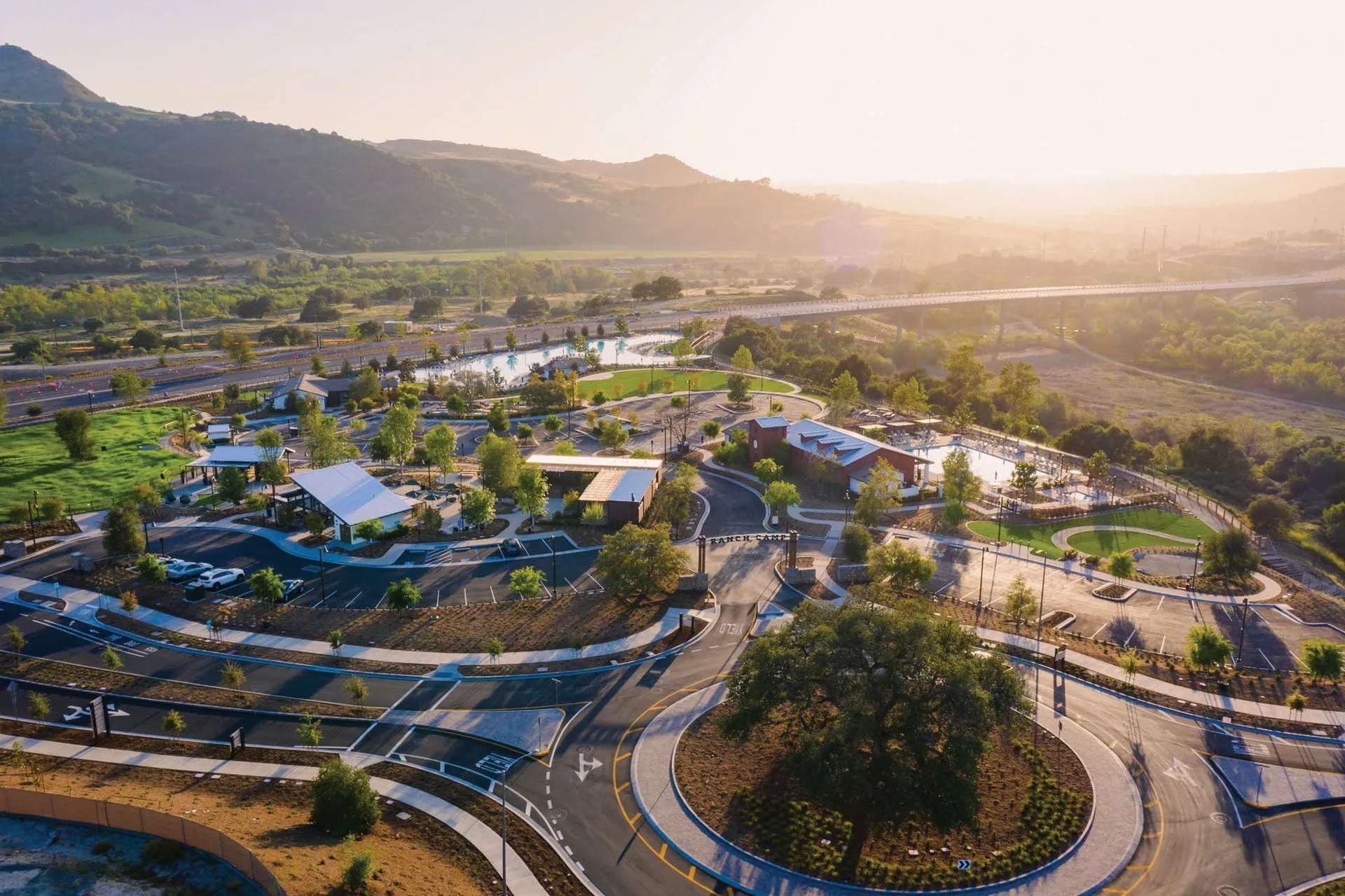 Area with buildings, paths, greenery, and hills
